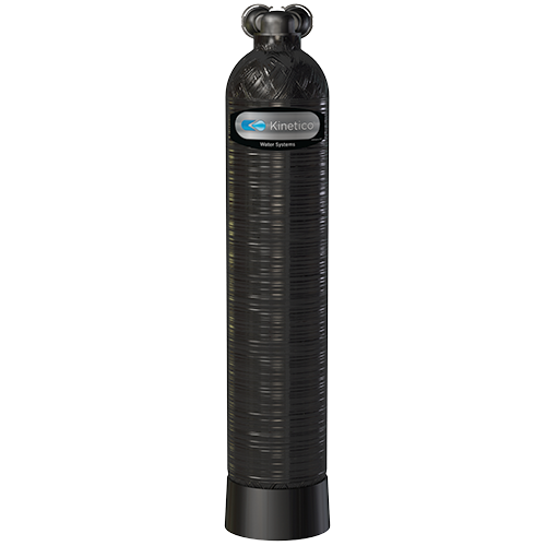 Kinetico water filtration system with a cylindrical black tank and a label on the front.